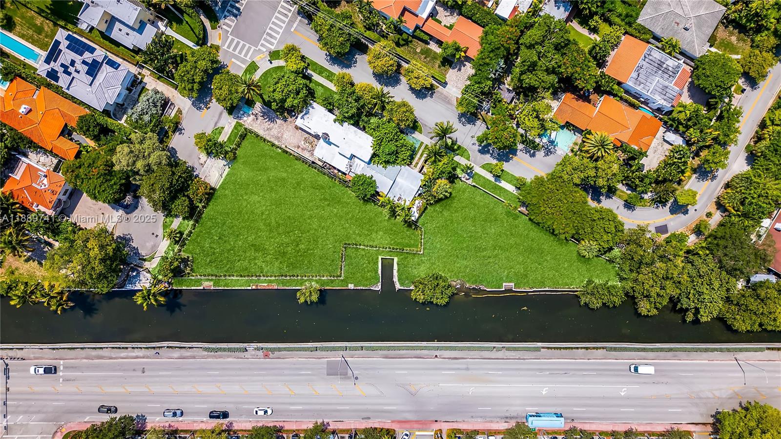 An aerial view shows a large, grassy waterfront lot bordered by a canal and road — 18th st Michigan Ave, Miami Beach FL 33139, MIAMI BEACH, FL
