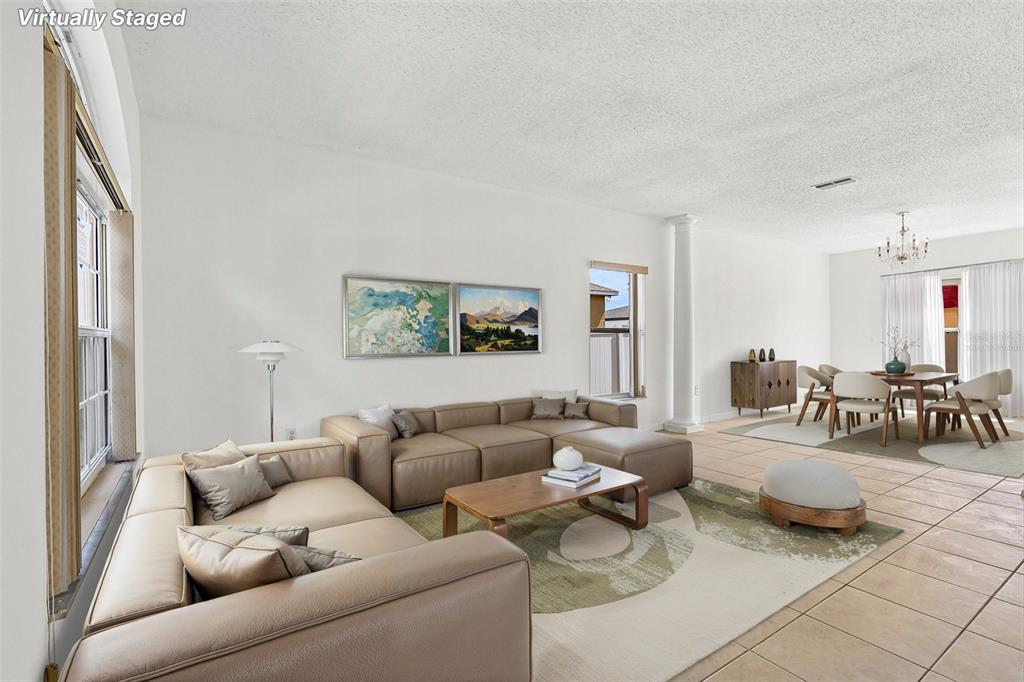 This virtually staged living and dining area features tile flooring and a neutral color palette — 1107 JAMES WAY, POINCIANA, FL