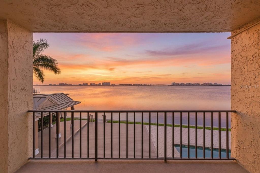 A balcony with a metal railing overlooks a calm bay at sunset — 602 LIME AVENUE UNIT 101, CLEARWATER, FL