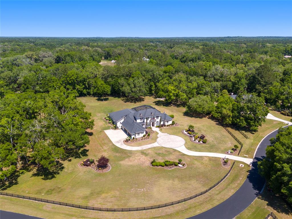 An aerial view shows a large house with a circular driveway surrounded by wooded acreage — 14742 NW 11TH PLACE, NEWBERRY, FL