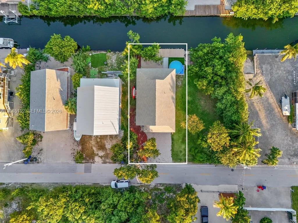 An aerial view shows a house with a small pool and dock along a canal — 3635 Trade Winds St, Big Pine FL 33043, BIG PINE, FL