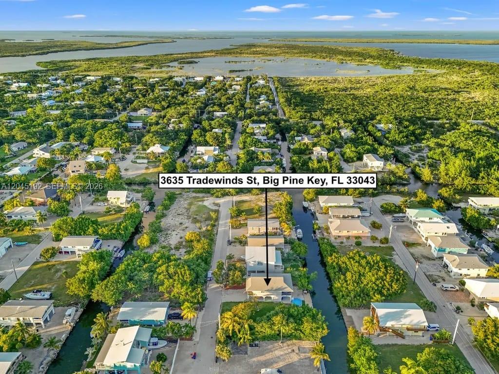 An aerial view shows a residential house situated along a canal in a coastal neighborhood — 3635 Trade Winds St, Big Pine FL 33043, BIG PINE, FL