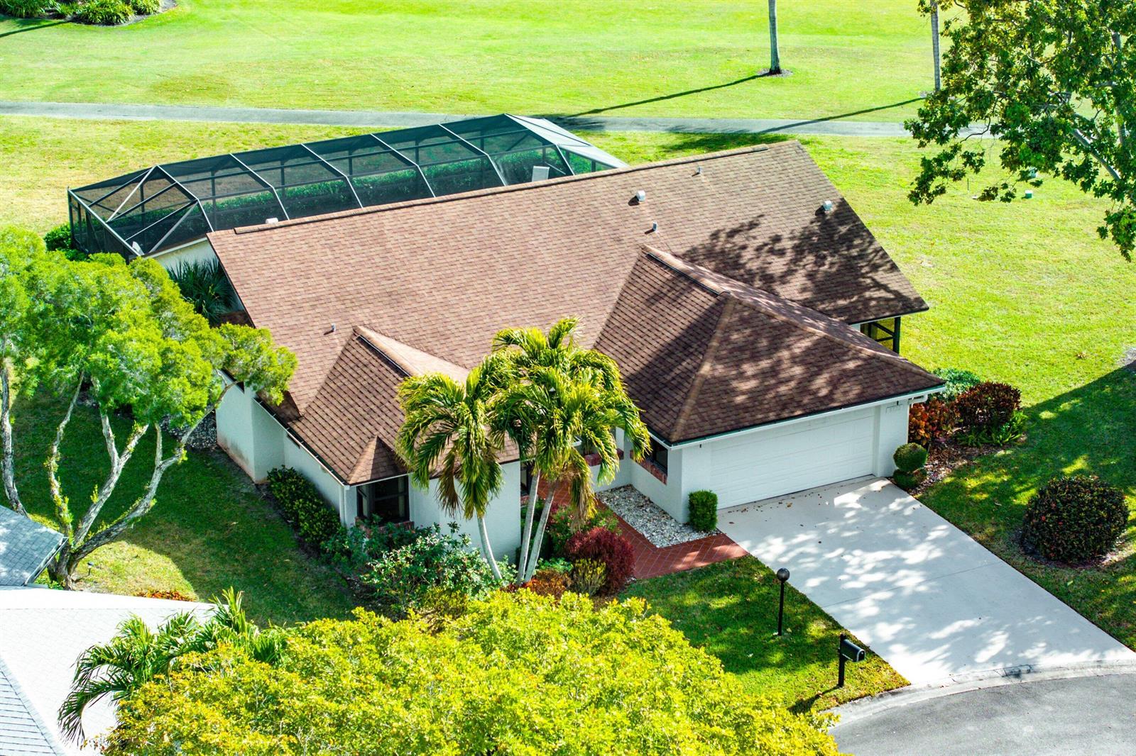 An aerial view of a single-story house with a brown roof and a screened pool enclosure — 5722 Willow Creek Lane, Delray Beach FL 33484, DELRAY BEACH, FL