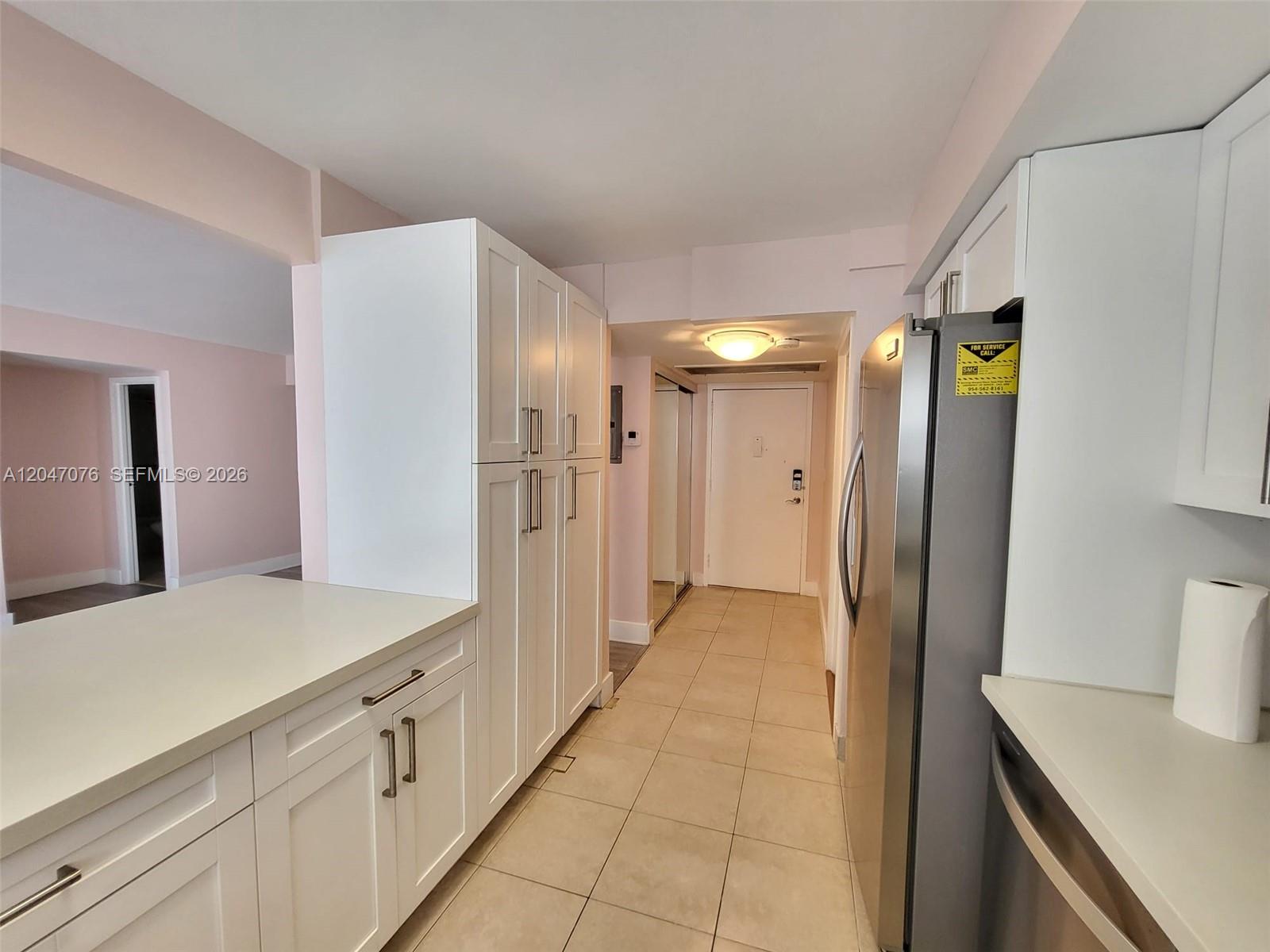 A kitchen features white cabinetry, stainless steel appliances, and light tile flooring — 501 Three Islands Blvd # 310, Hallandale Beach FL 33009, HALLANDALE BEACH, FL