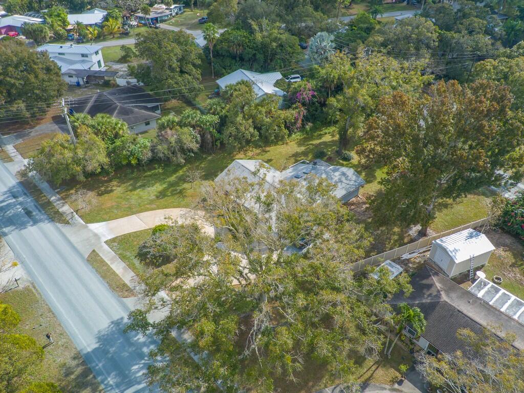 An aerial view shows a residential property with a house, driveway, and surrounding trees — 3105 Atlantic Boulevard, Vero Beach FL 32960, VERO BEACH, FL