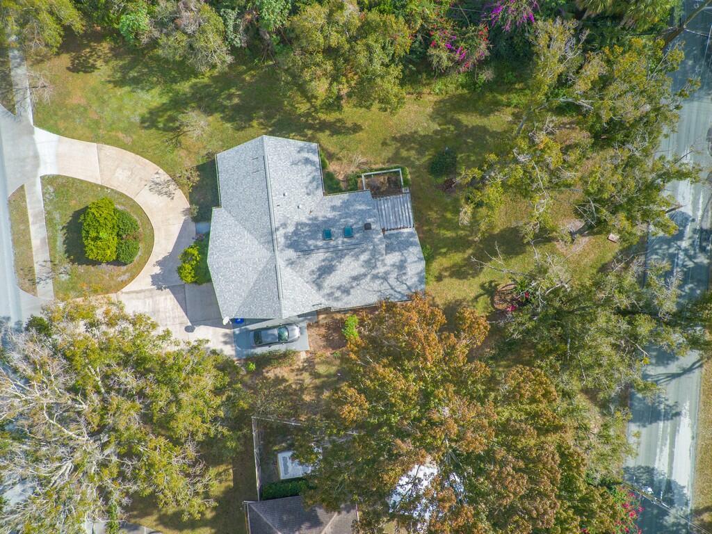 An aerial view shows a house with a gray roof, a driveway, and surrounding trees — 3105 Atlantic Boulevard, Vero Beach FL 32960, VERO BEACH, FL