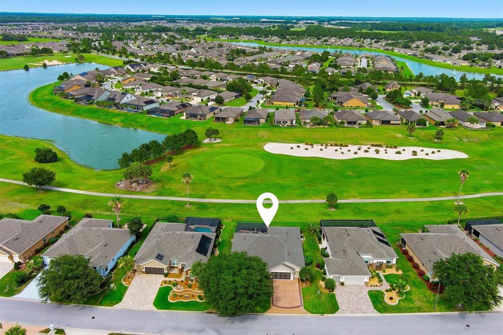An aerial view shows a suburban house with a pool overlooking a golf course — 6865 SW 97TH TERRACE ROAD, OCALA, FL