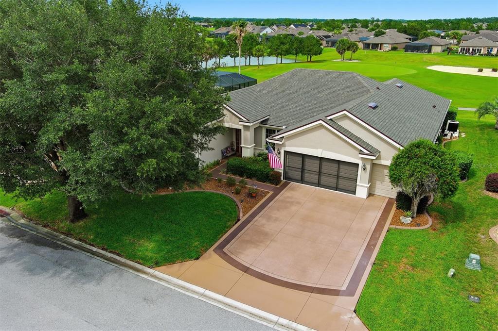 An aerial view of a single-story house with a garage, driveway, and golf course view — 6865 SW 97TH TERRACE ROAD, OCALA, FL