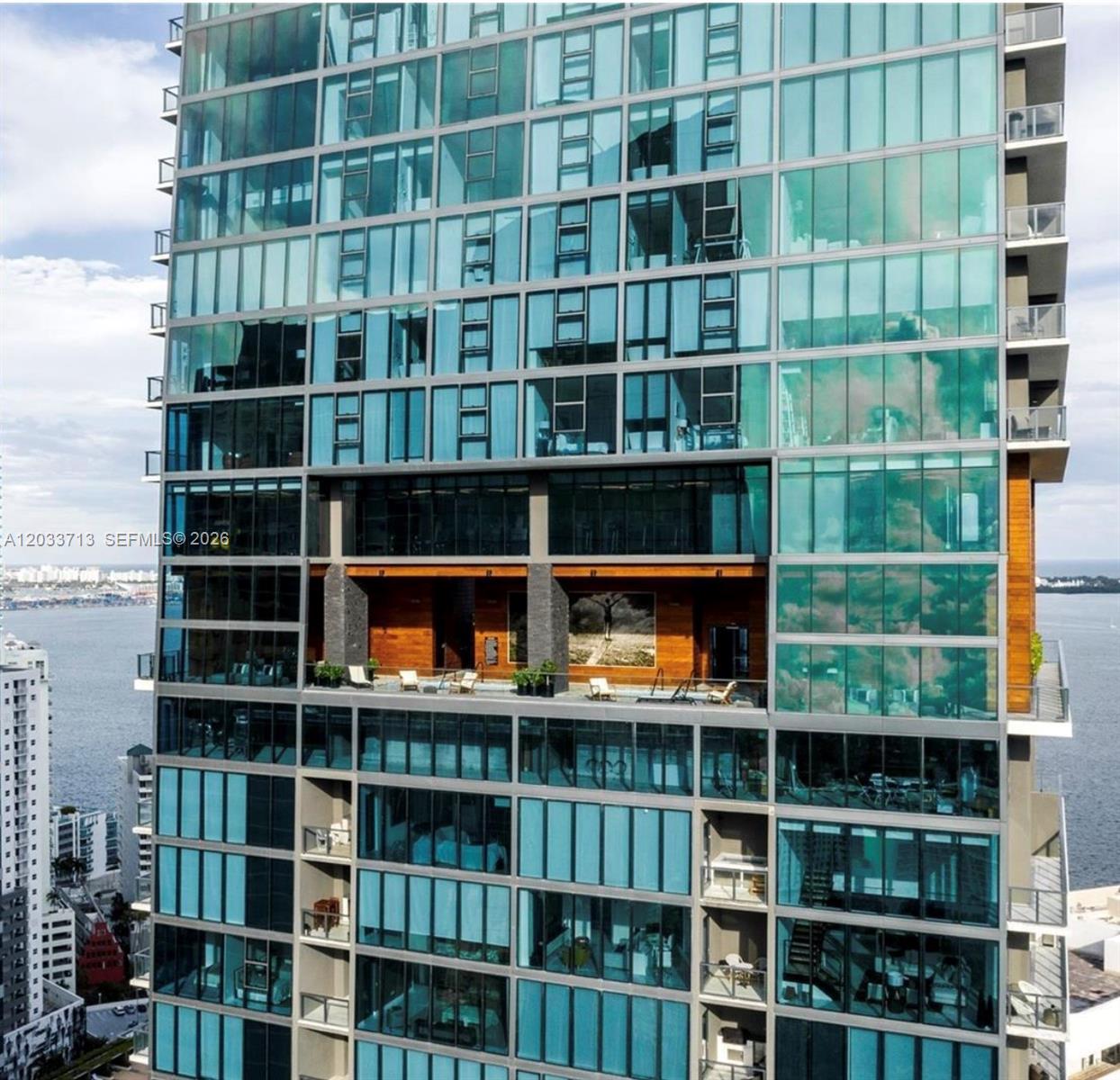 An exterior view of a high-rise building featuring a recessed terrace with wood paneling — 1451 Brickell Ave # 2701, Miami FL 33131, MIAMI, FL