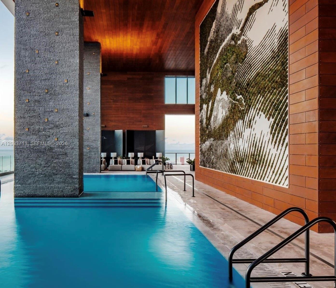 An indoor swimming pool features a textured stone pillar, wood-paneled walls, and a large mural — 1451 Brickell Ave # 2701, Miami FL 33131, MIAMI, FL
