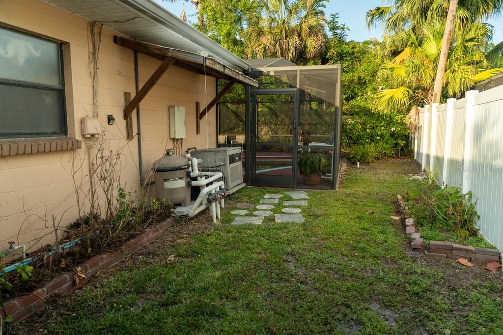A backyard view shows a house exterior, pool equipment, a screened lanai, and a white fence — 631 LUZON AVENUE, TAMPA, FL