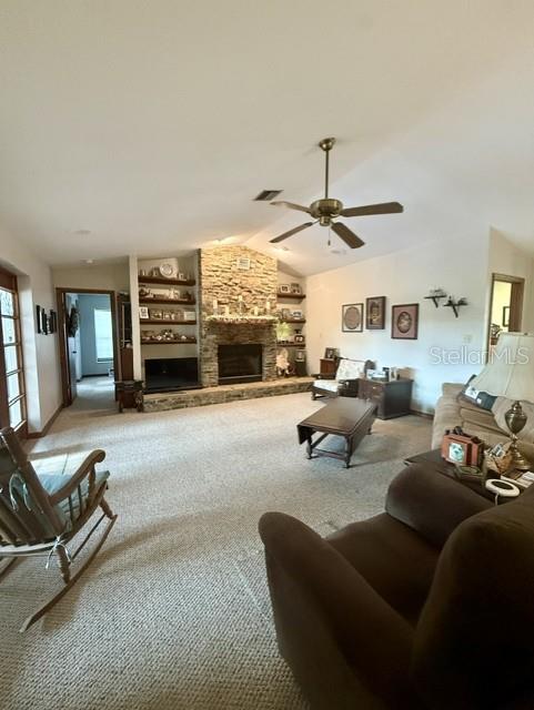 A living room features a stone fireplace, built-in shelving, a ceiling fan, and carpeted flooring — 33322 COUNTY ROAD 437, SORRENTO, FL