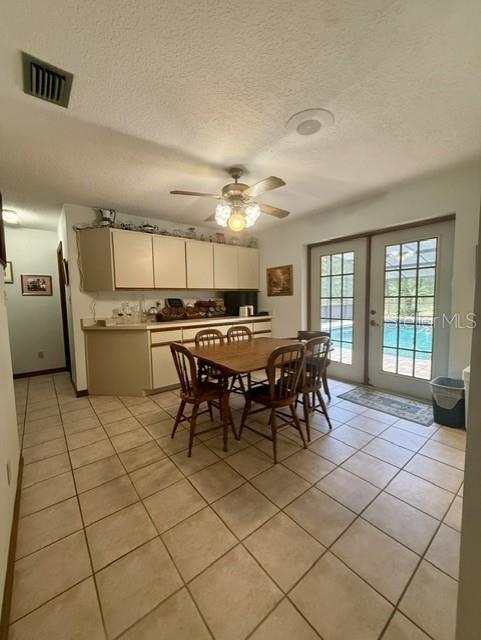 A kitchen and dining area with tile floors, wooden cabinets, and glass doors to a pool — 33322 COUNTY ROAD 437, SORRENTO, FL