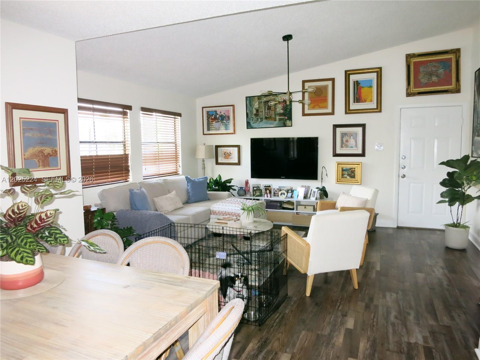 A living room and dining area feature wood-look flooring, a gallery wall, and neutral furniture — 15060 SW 103rd Ter # 6203, Miami FL 33196, MIAMI, FL