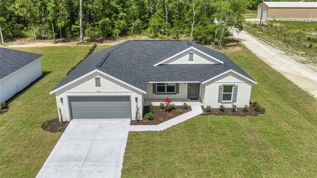 An aerial view of a single-story white house with a gray roof and garage — 4020 SW 156TH COURT, OCALA, FL