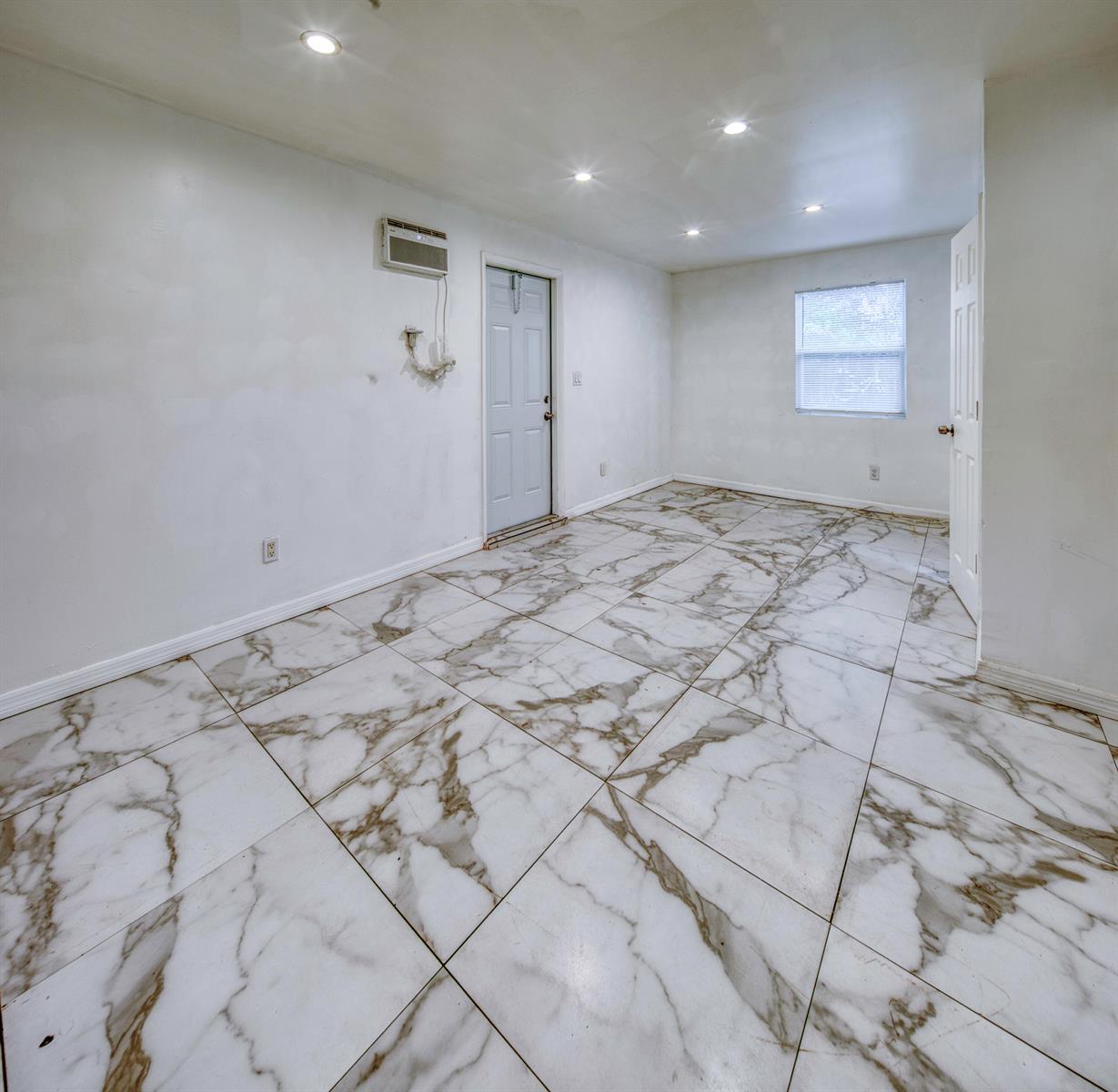 An empty room features white walls, recessed lighting, and large white marble-patterned floor tiles — 519 S M Street, FL 33460, FL
