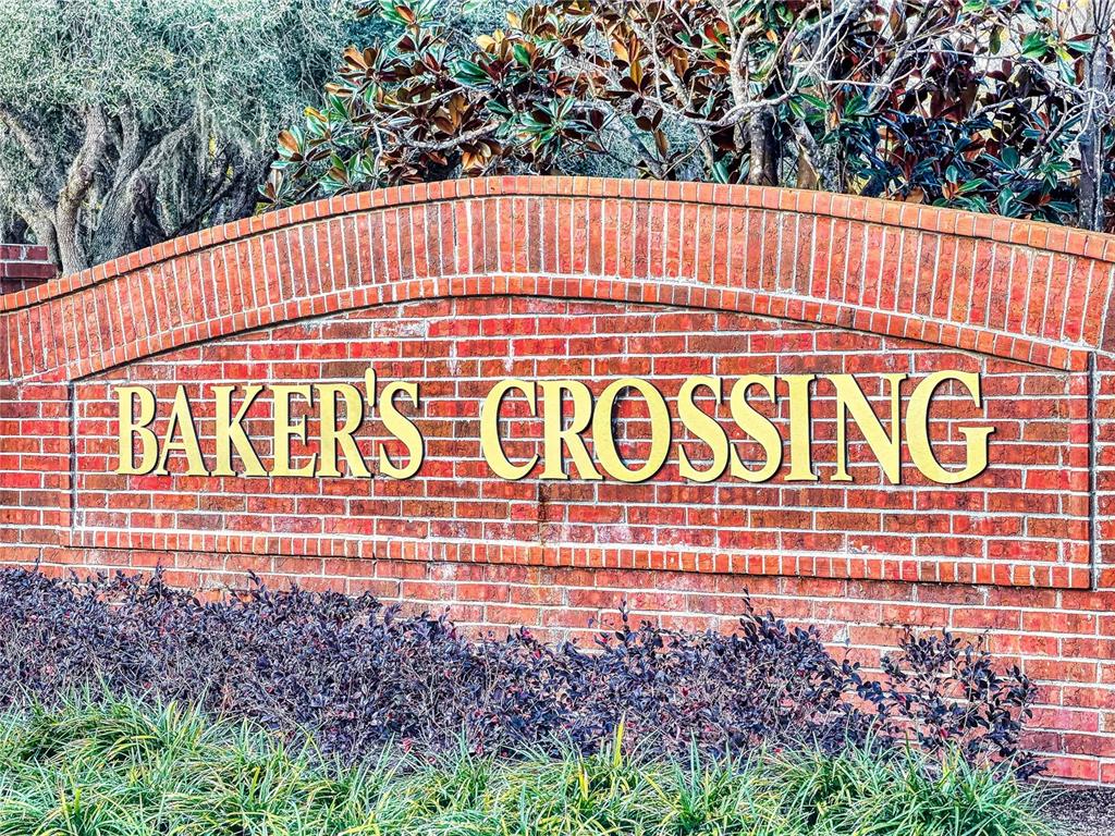 A brick monument sign with gold lettering reads Baker's Crossing in front of landscaping — 221 BELGIAN WAY, SANFORD, FL