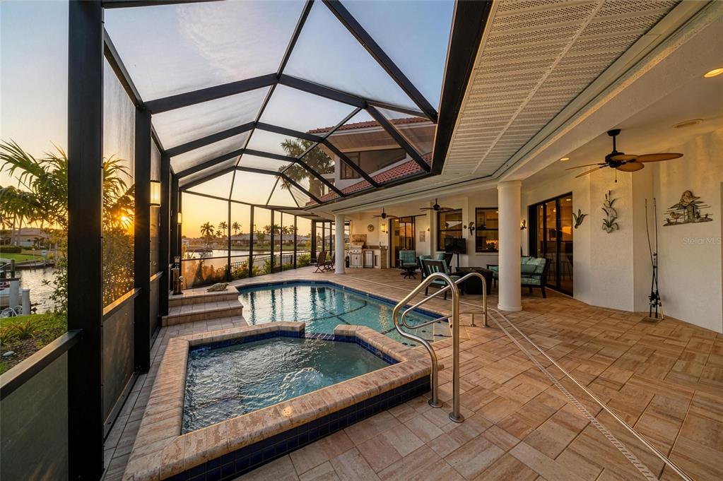 A screened-in patio features a swimming pool, a raised hot tub, and tile flooring — 524 LA CARUNA COURT, PUNTA GORDA, FL