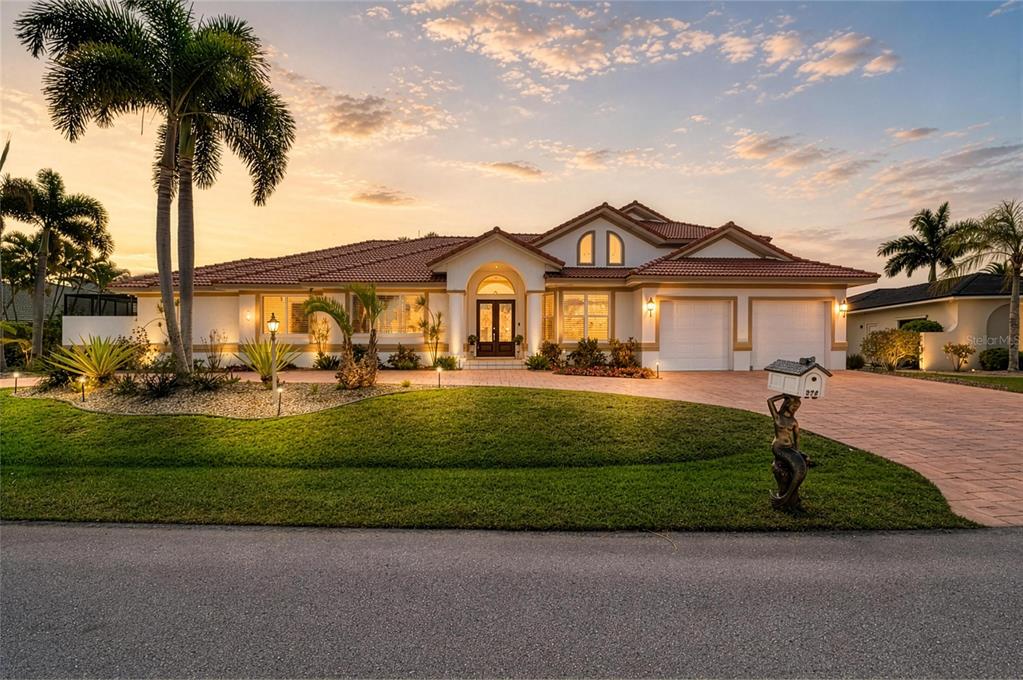 A single-story house with a tile roof, arched entryway, and a mermaid-themed mailbox — 524 LA CARUNA COURT, PUNTA GORDA, FL