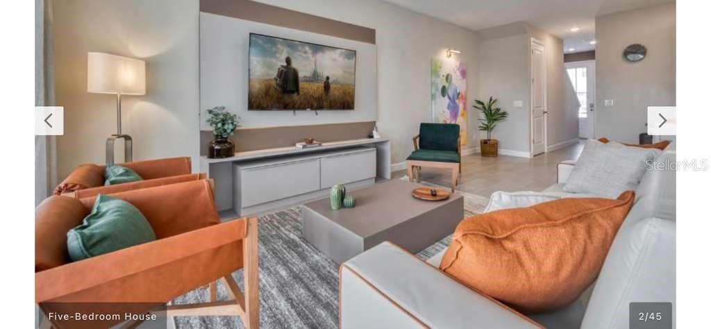 A modern living room features a wall-mounted television, leather armchairs, and a large coffee table — 8001 FORMOSA VALLEY, KISSIMMEE, FL