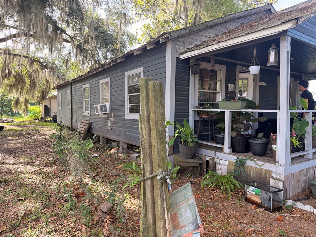 A dark-sided house with a front porch and a person standing on the porch — 139 NE PATTERSON AVENUE, LAKE CITY, FL
