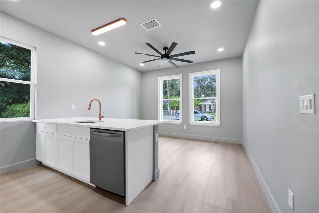 A kitchen island with a dishwasher and sink sits in a room with light flooring — 2034 E GRANT AVENUE, ORLANDO, FL