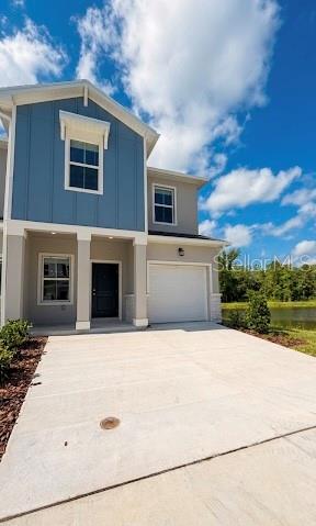 A two-story house with blue siding, a concrete driveway, and a single-car garage — 3045 CHROMATIC STREET, KISSIMMEE, FL
