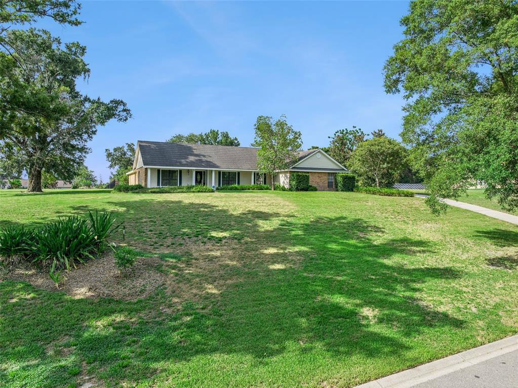 A single-story house with a brick and siding exterior sits on a large grassy lot — 9225 MCDAVID COURT, WINDERMERE, FL