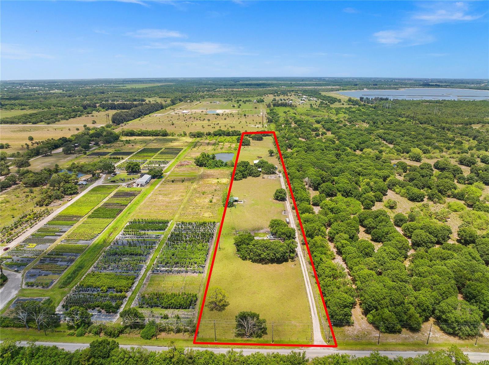 An aerial view shows a rectangular plot of land outlined in red near a road — 10120 W Midway Road, Fort Pierce FL 34945, FORT PIERCE, FL