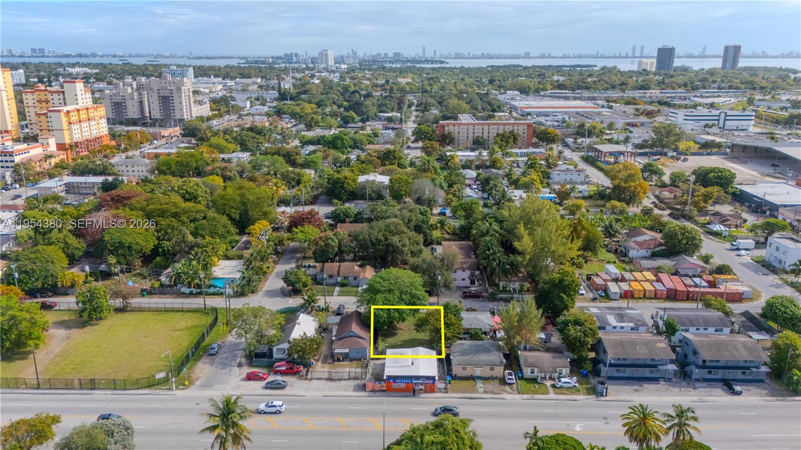 An aerial view shows a vacant rectangular lot highlighted in yellow between two small buildings — 7552 NE Miami Ct, Miami FL 33138, MIAMI, FL