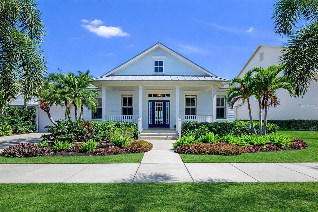 A light blue, single-story house with a front porch and a dark blue front door — 5237 BRIGHTON SHORE DRIVE, APOLLO BEACH, FL