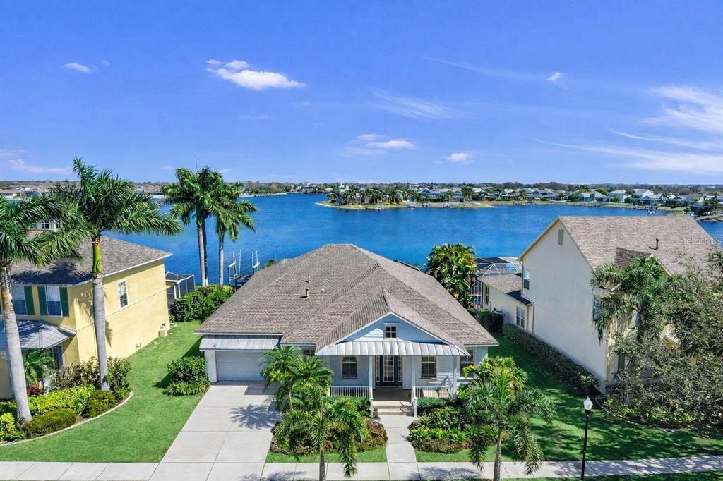 An aerial view of a light blue house with a gray roof near a lake — 5237 BRIGHTON SHORE DRIVE, APOLLO BEACH, FL