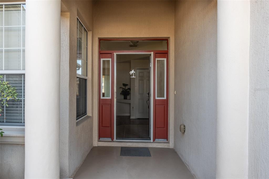 An exterior view of a front entryway with a red door and two side windows — 15803 SW 11TH COURT ROAD, OCALA, FL