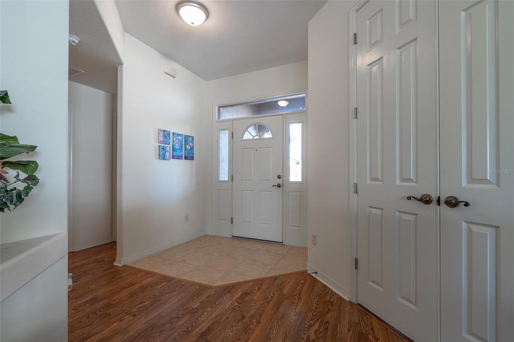 An entryway features a white front door, tile flooring, and wood-look laminate flooring — 15803 SW 11TH COURT ROAD, OCALA, FL