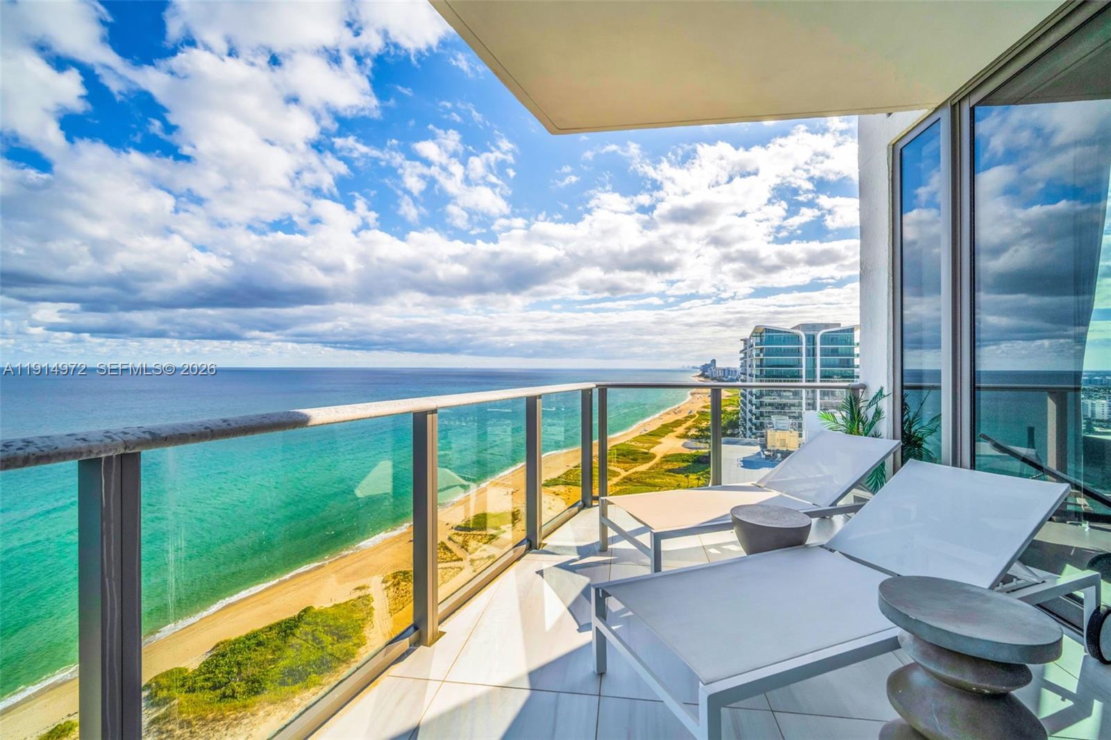 A balcony with two lounge chairs overlooks a sandy beach and the ocean — 1116 N Ocean Blvd, Pompano Beach FL 33062, POMPANO BEACH, FL