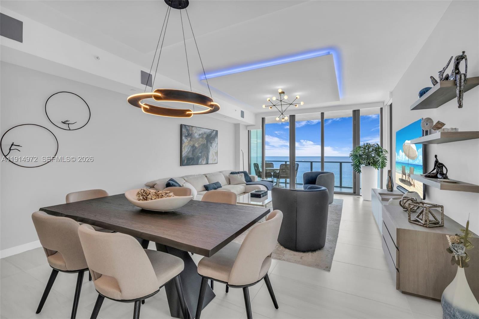 A modern living and dining area features a dark wood table, sectional sofa, and ocean views — 1116 N Ocean Blvd, Pompano Beach FL 33062, POMPANO BEACH, FL