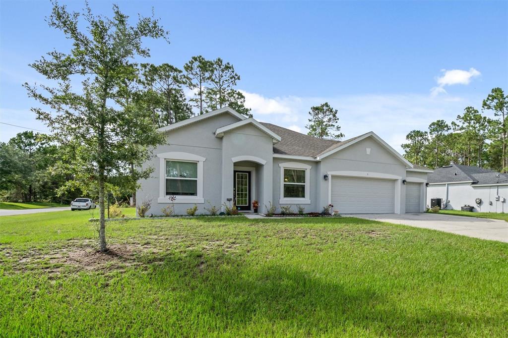 A single-story gray house with a two-car garage and a front lawn — 5 BUD HOLLOW DRIVE, PALM COAST, FL