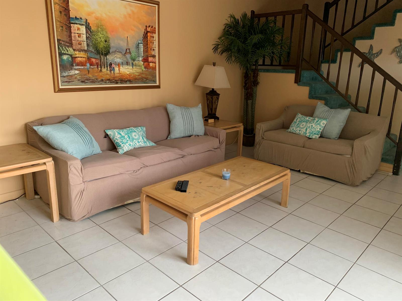 A living room features two beige sofas, a wooden coffee table, and a staircase — 9403 S Ocean Drive # 3d, Jensen Beach FL 34957, JENSEN BEACH, FL