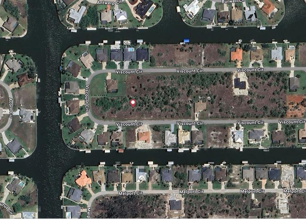 This aerial map shows a vacant residential lot surrounded by houses and a canal — 15723 VISCOUNT CIRCLE, PORT CHARLOTTE, FL