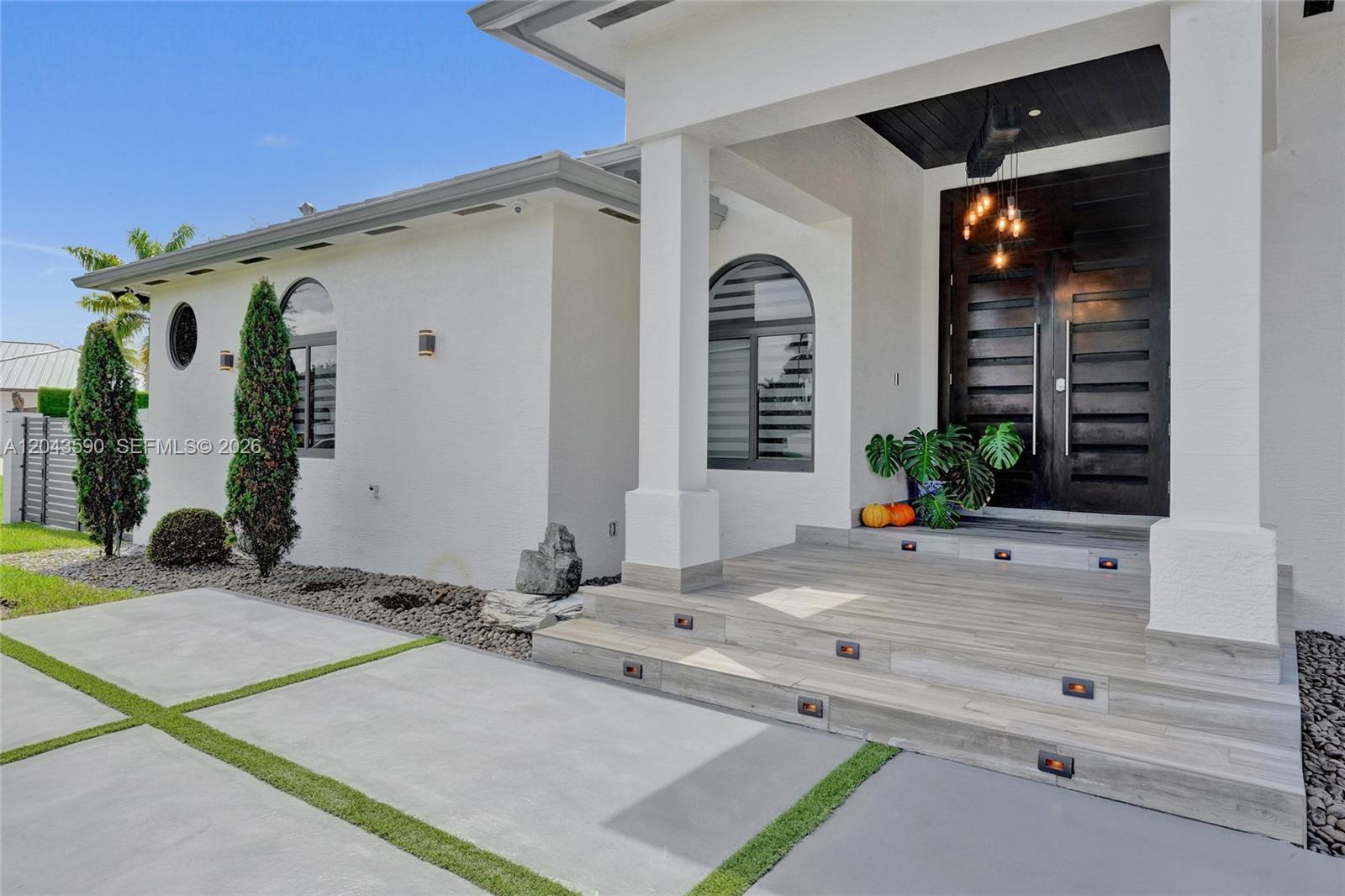 The exterior of a modern white house features a wooden front door and tiered steps — 2600 SW 128th Ct, Miami FL 33175, MIAMI, FL