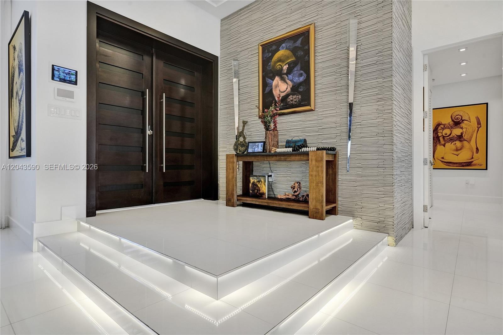 A modern entryway features a raised white tiled platform, dark wood doors, and stone wall — 2600 SW 128th Ct, Miami FL 33175, MIAMI, FL