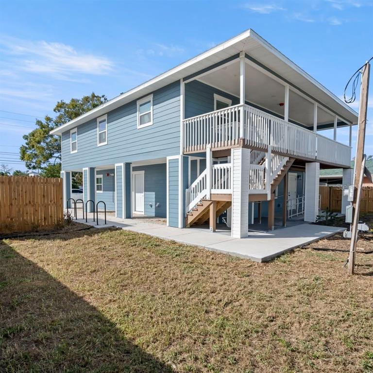An elevated blue house with a wooden staircase leading to a covered second-story deck — 3107 16TH STREET N, ST PETERSBURG, FL