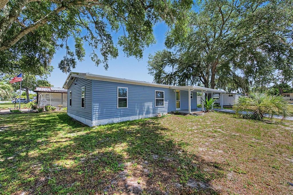 A blue single-wide mobile home with a white brick base sits on a grassy lot — 7338 FIRST LOOP AVENUE, BROOKSVILLE, FL