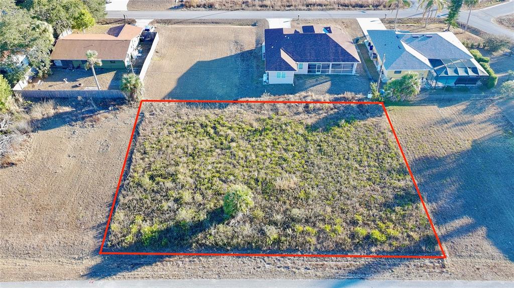 An aerial view shows a rectangular, undeveloped vacant lot outlined in red — Lots 22 & 23 LORANZA AVENUE, NORTH PORT, FL