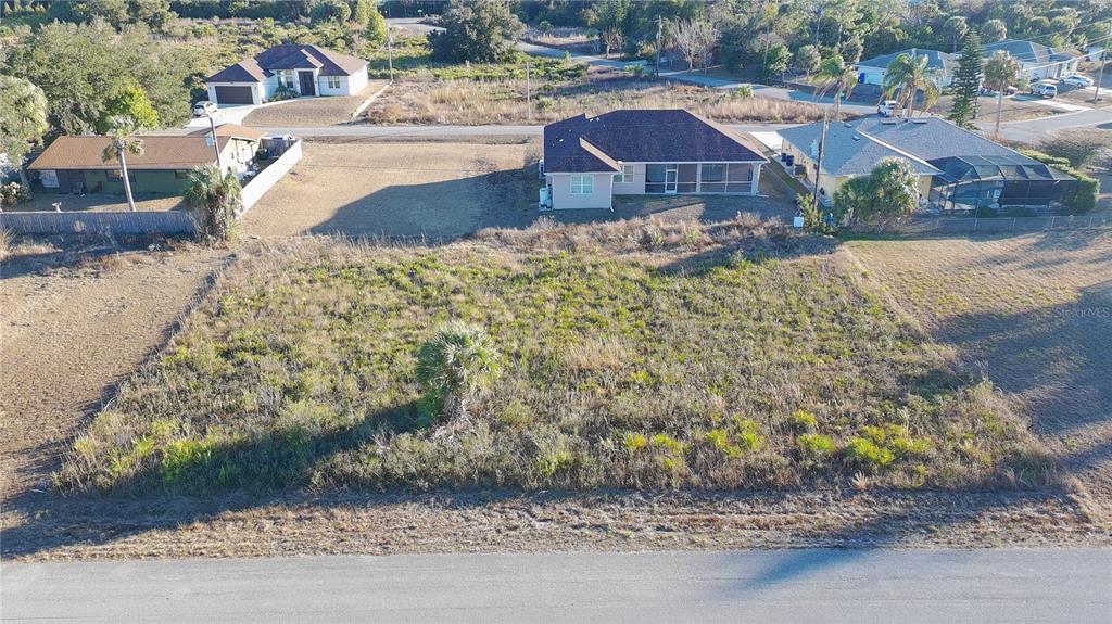 An aerial view shows a vacant, rectangular residential lot situated between two existing houses — Lots 22 & 23 LORANZA AVENUE, NORTH PORT, FL