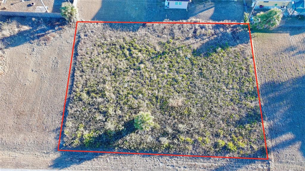 An aerial view shows a rectangular, undeveloped vacant lot outlined in red — Lots 22 & 23 LORANZA AVENUE, NORTH PORT, FL