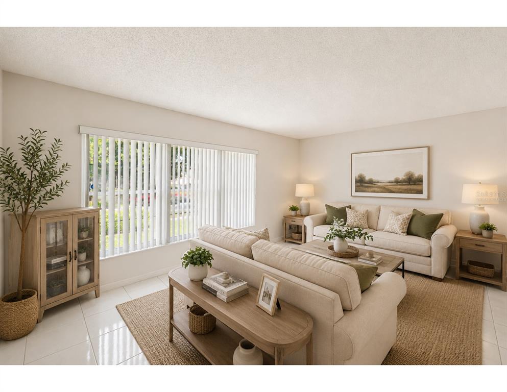 A living room features a beige sofa, a wooden console table, and vertical window blinds — 8206 VASSAR CIR, TAMPA, FL