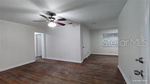 An interior view of a room with wood-look flooring, white walls, and a ceiling fan — 3214 DIAN ROAD, TALLAHASSEE, FL