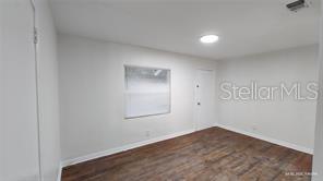 An empty room features light gray walls, a single window, and dark wood-look flooring — 3214 DIAN ROAD, TALLAHASSEE, FL