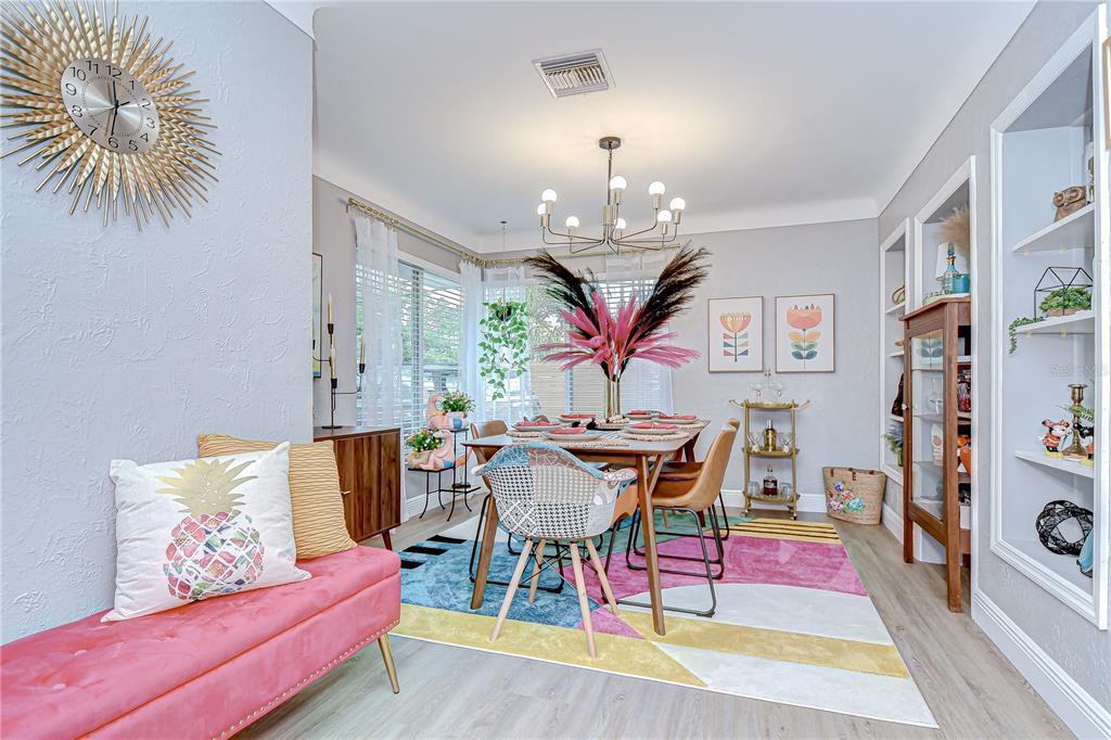 A dining room features a colorful rug, a wooden table, and a pink bench — 130 63RD STREET S, ST PETERSBURG, FL